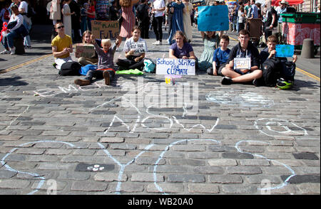 Il Royal Mile di Edimburgo, Scozia, Regno Unito.23 agosto 2019. Con lo sfondo del trambusto della frangia scozzese sciopero della gioventù aveva un tranquillo sedersi protesta sulla strada alta. Scottish Gioventù sciopero del clima (SYCS) è un collettivo di appassionati , determinato i giovani chiedono giustizia climatica dal governo scozzese. SYCS scuola organizzare scioperi e manifestazioni di protesta in città al oltre la Scozia. Foto Stock