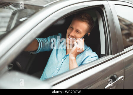 Giovane uomo bello rigidi aventi unsafely conversazione sul suo smartphone durante la corsa Foto Stock