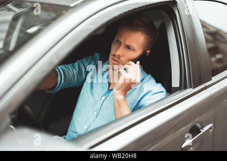 Giovane uomo bello rigidi unsafely parlando sul suo smartphone durante la corsa Foto Stock
