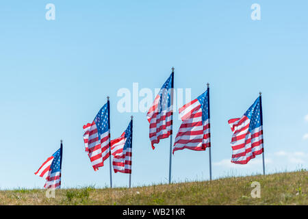 National american flag su erba verde contro il cielo blu con nuvole Foto Stock