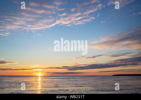 Il sole che tramonta su un porto congelati nelle zone rurali di Prince Edward Island, Canada. Foto Stock