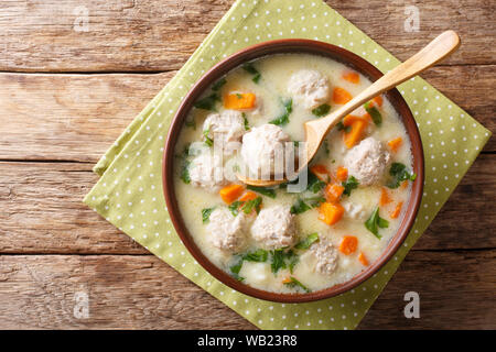 Il bulgaro chorba topcheta zuppa con polpette di carne, yogurt e verdure close-up in una ciotola sul tavolo. Parte superiore orizzontale vista da sopra Foto Stock