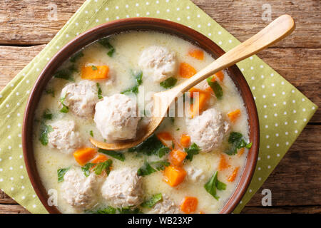 Gustosa zuppa bulgara topcheta con polpettine di close-up in una ciotola sul tavolo. parte superiore orizzontale vista da sopra Foto Stock