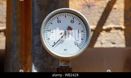Alta pressione dei manometri, tubazioni e valvole, sfocatura dello sfondo industriale Foto Stock