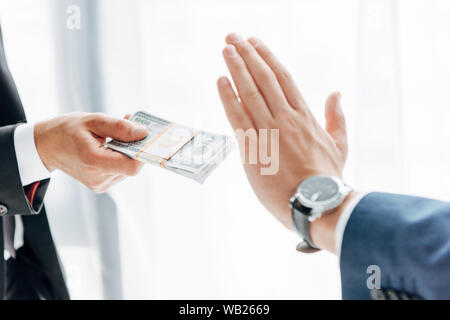 Vista ritagliata dell'uomo dare tangenti al business partner gesticolando su bianco Foto Stock