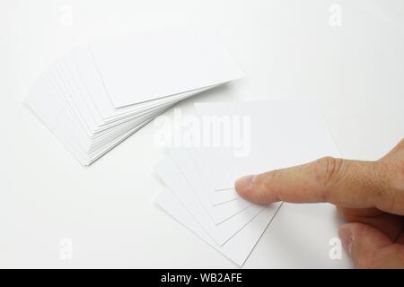 Biglietti da visita in cartoncino bianco con la scrittura di spazio. Alcune schede aziendali sono isolati dal resto della pila. Foto Stock