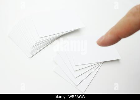 Biglietti da visita in cartoncino bianco con la scrittura di spazio. Alcune schede aziendali sono isolati dal resto della pila. Foto Stock