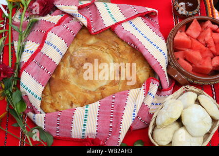 Pane appena sfornato il pane fatto in casa disposti in tradizionali bulgare tessili. Immagine di alcuni gustosi piatti fatti in casa a base di prodotti da forno. Pane fresco Foto Stock