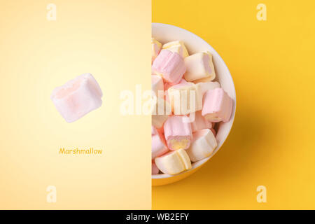 Layout creativo fatto di marshmallows colorati in piastra su sfondo giallo Foto Stock