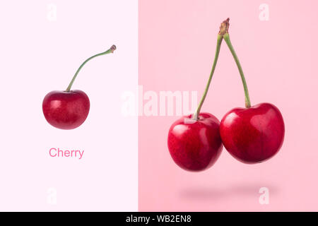 Layout creativo fatto di ciliegia di colore rosso su sfondo rosa, minimalismo creativo Foto Stock