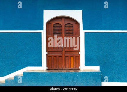 Facciata con pareti blu e porta in legno nel centro storico di Granada in stile coloniale spagnolo, Nicaragua. Foto Stock