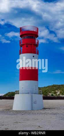 Il rosso e bianco piccolo faro sull isola - Dune Helgoland - Germania con cielo blu Foto Stock