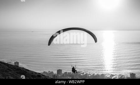 I parapendii lancio da Cape Town Signal Hill al tramonto sopra il borgo Seapoint sul Sud Africa litorale atlantico Foto Stock