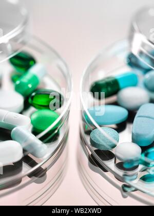 La ricerca farmaceutica, immagine concettuale. Una varietà di farmaci seduto in una capsula di petri. Foto Stock