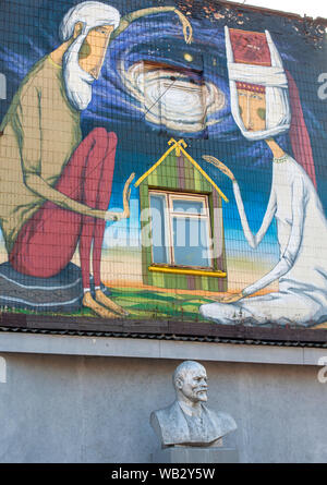 Un busto di Lenin contro uno sfondo di graffiti street art su un edificio sulla strada Oktyabrskaya a Minsk, in Bielorussia. Foto Stock