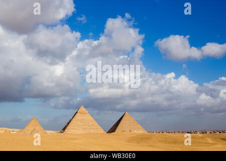 Tre piramidi (da destra a sinistra) Khufu, Khafre e Menkuare in Egitto la mattina nuvoloso giorno, lo sfondo è la città di Giza. I tre piccoli Foto Stock