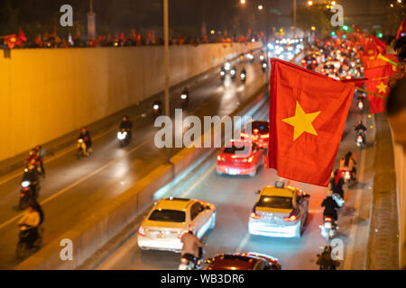 Il vietnamita bandiere con la folla di Vietname i tifosi di calcio in giù lungo la strada per festeggiare la vittoria dopo il calcio Foto Stock