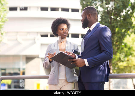 Paio di business partner per il controllo della documentazione di lavoro all'aperto Foto Stock