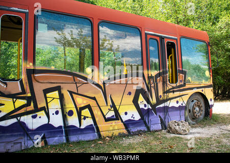 Dobrich/Bulgaria - Agosto 18 2019: scuola bus dipinta con graffiti nella foresta del locale zoo. Foto Stock