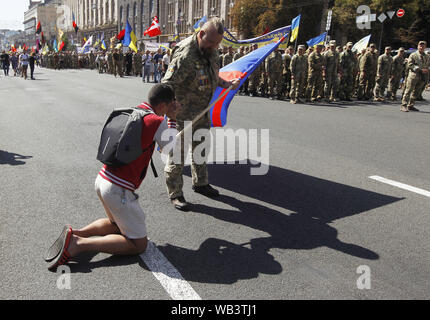 Kiev, Ucraina. 24 Ago, 2019. Un uomo si erge sulle sue ginocchia come egli dimostra il suo rispetto per Ukrainan combattenti che hanno partecipato in un conflitto militare in Ucraina orientale, durante il 'Marco di difensori dell'Ucraina" in occasione del Giorno di Indipendenza sulla piazza Indipendenza a Kiev, Ucraina, 24 agosto 2019. Gli ucraini contrassegnare il 28 anniversario dell'indipendenza dell'Ucraina dall'Unione Sovietica a partire dal 1991. Credito: Serg Glovny/ZUMA filo/Alamy Live News Foto Stock