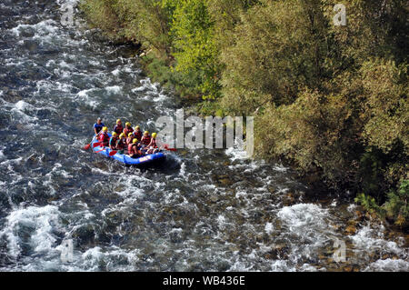 Rafting, un gruppo di giovani con una guida rafting lungo un fiume di montagna. Extreme e divertente sport a una attrazione turistica. Foto Stock