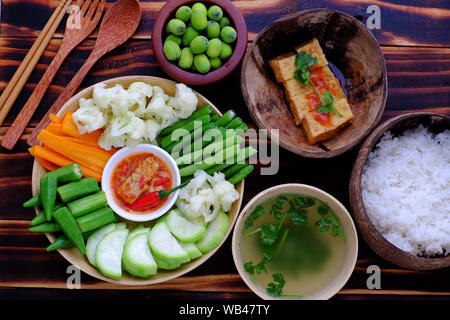 vista dall'alto vassoio di cibi fatti in casa per vegan, verdure bollite come carota, calabash, okra, fagiolo a corda, broccoli, formaggio tofu, salsa di pomodoro tofu fritta, riso Foto Stock