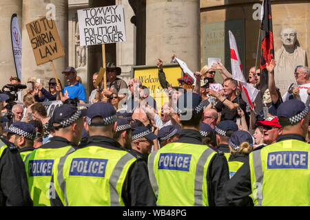 Portland Place, Londra, Regno Unito. 24 agosto 2019. I manifestanti si radunano a sostegno di Tommy Robinson, opponendosi alla legge della Sharia, sotto la supervisione della polizia nel centro di Londra. I segni visibili includono "NO ALLA LEGGE DELLA SHARIA" e "TOMMY ROBINSON PRIGIONIERO POLITICO". Protesta libera di Tommy Robinson fuori dalla BBC. Allo stesso tempo si sta svolgendo una contromanifestazione, organizzata da Stand Up to razzism and Unite Against fascism. Penelope Barritt/Alamy Live News Foto Stock