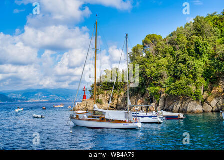 Portofino, Italia - 15 agosto 2019: Yachts vicino alla montagna rocciosa nella baia. Foto Stock