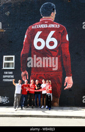 Liverpool. UK.24 agosto 2019; Anfield, Liverpool, Merseyside England; English Premier League Football, Liverpool contro l'Arsenal Football Club; ventilatori posano per una foto di fronte al gigantesco murale di Trento Alexander-Arnold di Liverpool dipinta sul lato della casa vicino allo stadio - rigorosamente solo uso editoriale. Nessun uso non autorizzato di audio, video, dati, calendari, club/campionato loghi o 'live' servizi. Online in corrispondenza uso limitato a 120 immagini, nessun video emulazione. Nessun uso in scommesse, giochi o un singolo giocatore/club/league pubblicazioni Credit: Azione Plus immagini di sport/Alamy credito Live: Azione Foto Stock