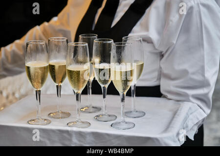 Sezione mediana del cameriere che serve vino Prosecco in bicchieri durante la cerimonia di nozze Foto Stock