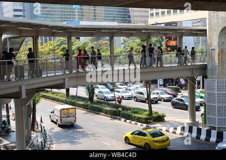 Gruppo di persone che camminano sulla passerella elevata al Siam Square area, famoso centro shopping di Bangkok, Thailandia Foto Stock