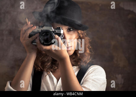 Donna fotografo con Bowler e Giarrettiere tenendo un sigaro Foto Stock