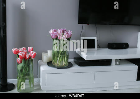 I tulipani in un vaso su un tavolo di legno. Interni scandinavi. Mockup Foto Stock