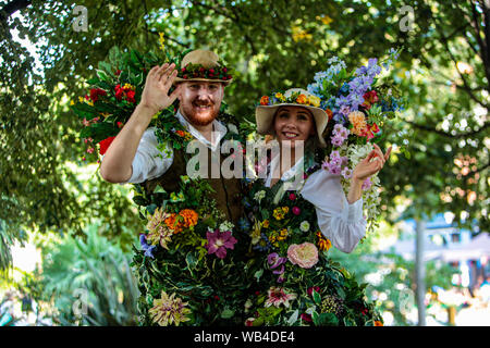 Londra, Regno Unito. 24 Ago, 2019. Vauxhall Pleasure Gardens sono stati presi indietro nel tempo per l'esperienza di stile vittoriano, questo piccolo angolo di sud di Londra è stato trasformato in stile vittoriano di un parco divertimenti a tema, con vivace e divertente, curioso circus interpreti e musica portando spettacoli Vittoriana alla vita di tutta la giornata. Lungo con funamboli, uomini forti, music hall bande, trampolieri il signor e la signora Flora sono interamente costume in profumi di fiori di seta.Paolo Quezada-Neiman/Alamy Live News Credito: Paolo Quezada-Neiman/Alamy Live News Foto Stock