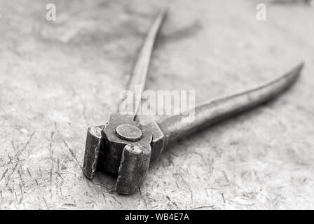 Vecchio pinze giacciono su un arrugginito shabby superficie metallica Foto Stock