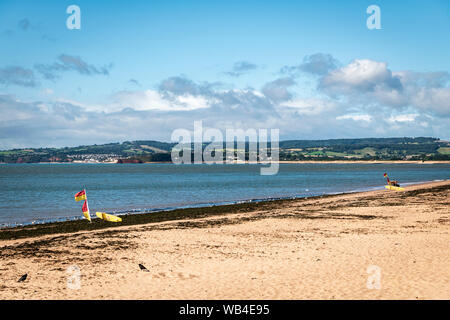 RNLI safe area nuoto segnato dal rosso e giallo le bandiere e tavole da surf sulla spiaggia di Exmouth, Devon, Inghilterra. 14 Agosto 2019 Foto Stock