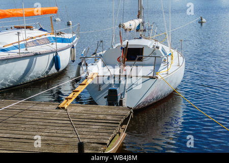 Due piccole barche a vela ormeggiata presso un molo in legno Foto Stock