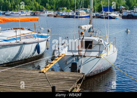 Piccole barche a vela ormeggiata presso un molo in legno Foto Stock