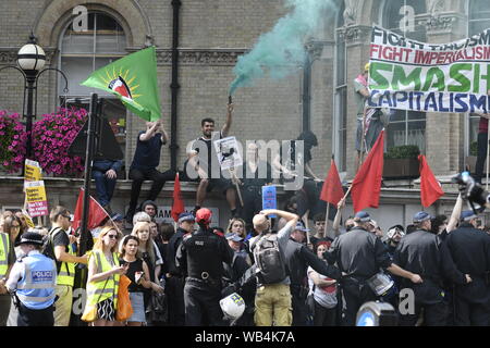 Anti-fascismo manifestanti tenere le bandiere e una svasatura di masterizzazione durante il rally.sostenitori radunati fuori BBC per esigere la libertà dei loro incarcerato a destra leader Stephen Yaxley-Lennon alias Tommy Robinson. Durante il rally, la polizia ha dovuto intervenire e alzare i loro manganelli quando un furgone della polizia è stato attaccato da Tommy Robinson sostenitori. Una persona è stata arrestata dopo il confronto. Foto Stock