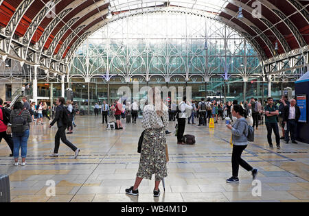 Vista posteriore di gente giovane donna in elegante moda estate gonna in piedi in attesa a Paddington Station stazioni Londra Inghilterra UK KATHY DEWITT Foto Stock