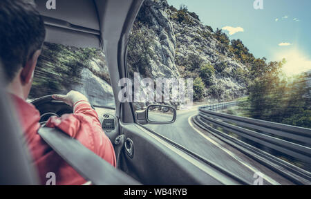 Il conducente si precipita lungo la strada di montagna in auto. Vista dall'interno dell'auto. Foto Stock