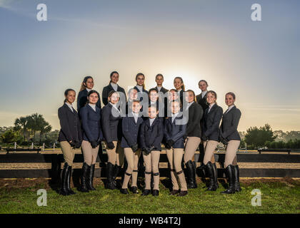 Un gruppo di giovani donne inglese piloti in uniforme sono in posa per la fotocamera insieme all'esterno prima della loro competizione equestre Foto Stock