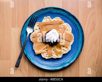 Formaggio norvegese marrone su un waffle con marmellata di fragole e panna acida Foto Stock