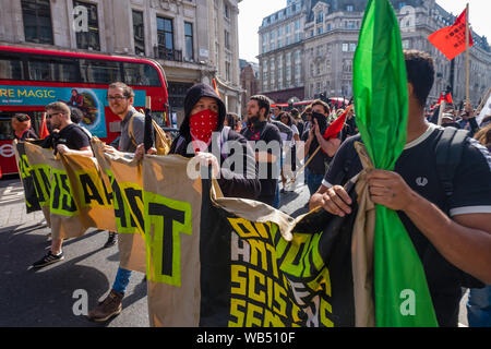 Londra, Regno Unito. 24 agosto 2019. Anti-fascisti marzo per opporsi a una protesta presso la BBC da Tommy Robinson sostenitori che affermano che egli è in carcere per il giornalismo. Egli è stato condannato a 9 mesi per 3 reati al di fuori di Leeds Crown Court che potrebbe aver causato il crollo di una toelettatura pista di prova e ha precedenti condanne per violenza, finanziari e frodi in materia di immigrazione, del possesso di droga e di ordine pubblico reati. La polizia ha mantenuto la due gruppi separati. Robinson sostenitori sono stati successivamente unite dai dimostranti da Trafalgar Square, e un gruppo di grandi dimensioni dal supporto fino al razzismo è venuto per unire Antifa. Peter Marshall / Alamy Live Foto Stock