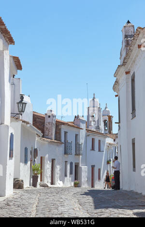 Una strada che conduce alla chiesa di Santa Maria da Lagoa nel villaggio di collina di Monsaraz nella regione dell'Alentejo, in Portogallo. Foto Stock