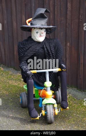 Rennington, Inghilterra, 24 agosto 2019. Una strega a cavallo di un bambino durante il triciclo The scarecrow festival che si tiene ogni anno a Ferragosto weekend. Foto Stock