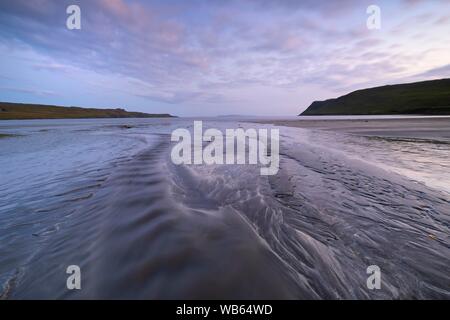 Flusso scorre sulla spiaggia di sabbia nel mare e le forme delle strutture, la bassa marea sulla spiaggia di Glenbrittle, Isola di Skye in Scozia Foto Stock