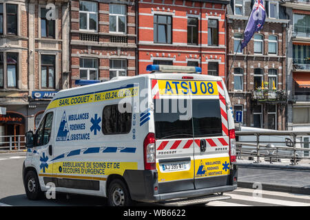 Dinant, Belgio - 26 Giugno 2019: il bianco e il giallo ambulanza van su Charles de Gaule Bridge. Pub e ristoranti nel retro. Foto Stock