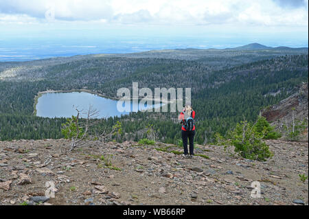 Escursionista femmina godendo la vista dal Tam McArthur Rim Trail in tre sorelle deserto vicino alle sorelle, Oregon. Foto Stock