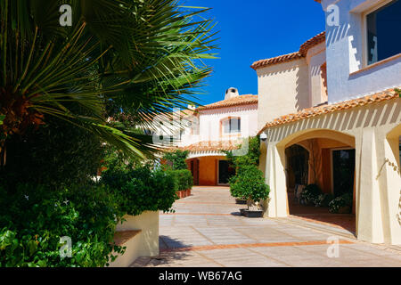 Paesaggio con palme e casa residenziale complesso. Appartamento Edificio. Home costiera di architettura di Porto Cervo in Sardegna in Italia Foto Stock